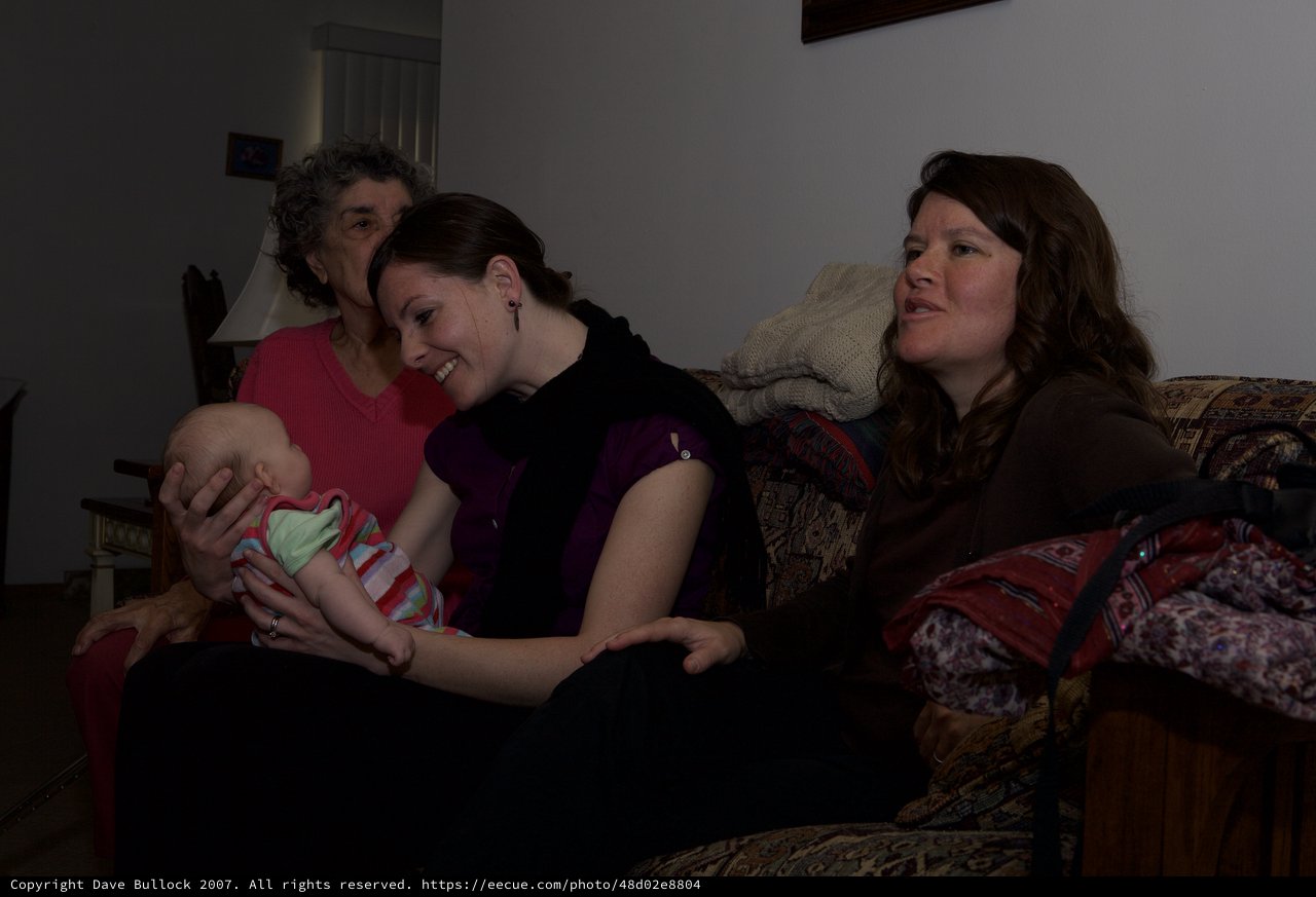 Three Generations Share a Tender Moment with Newborn