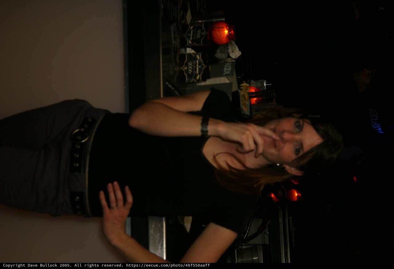 Woman in Black at Dimly Lit Bar Counter