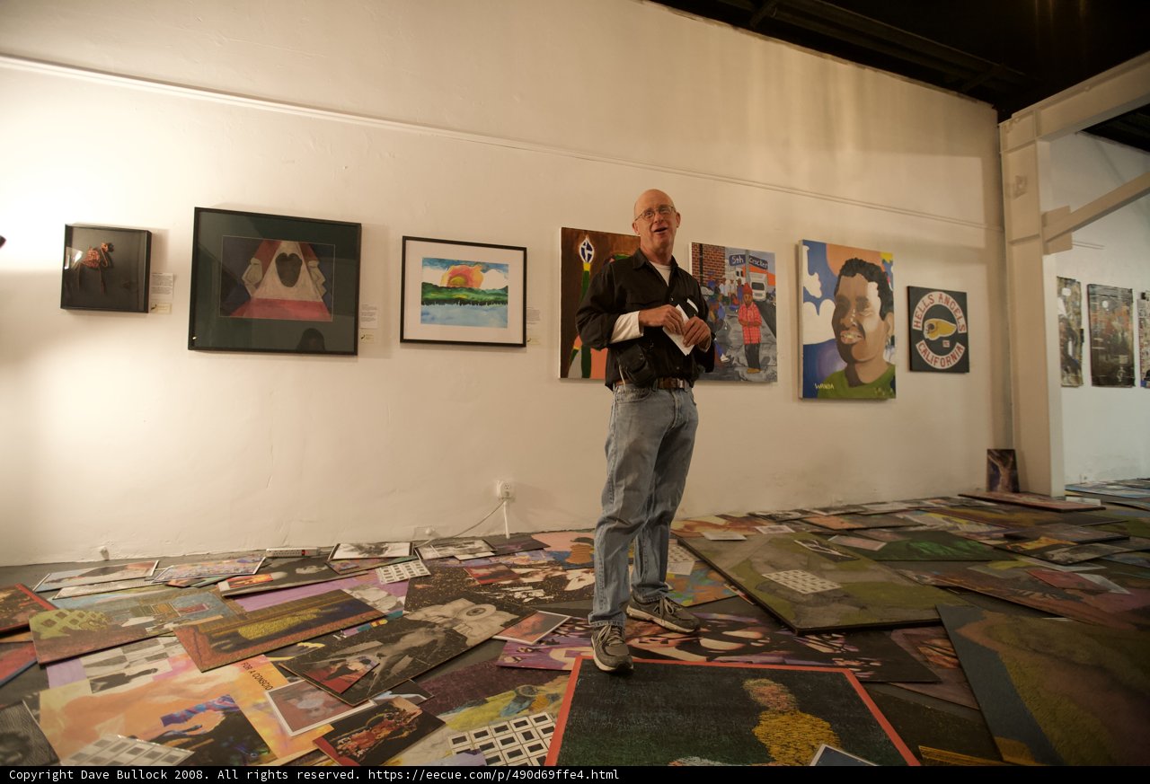 Man Admiring Paintings on Gallery Floor