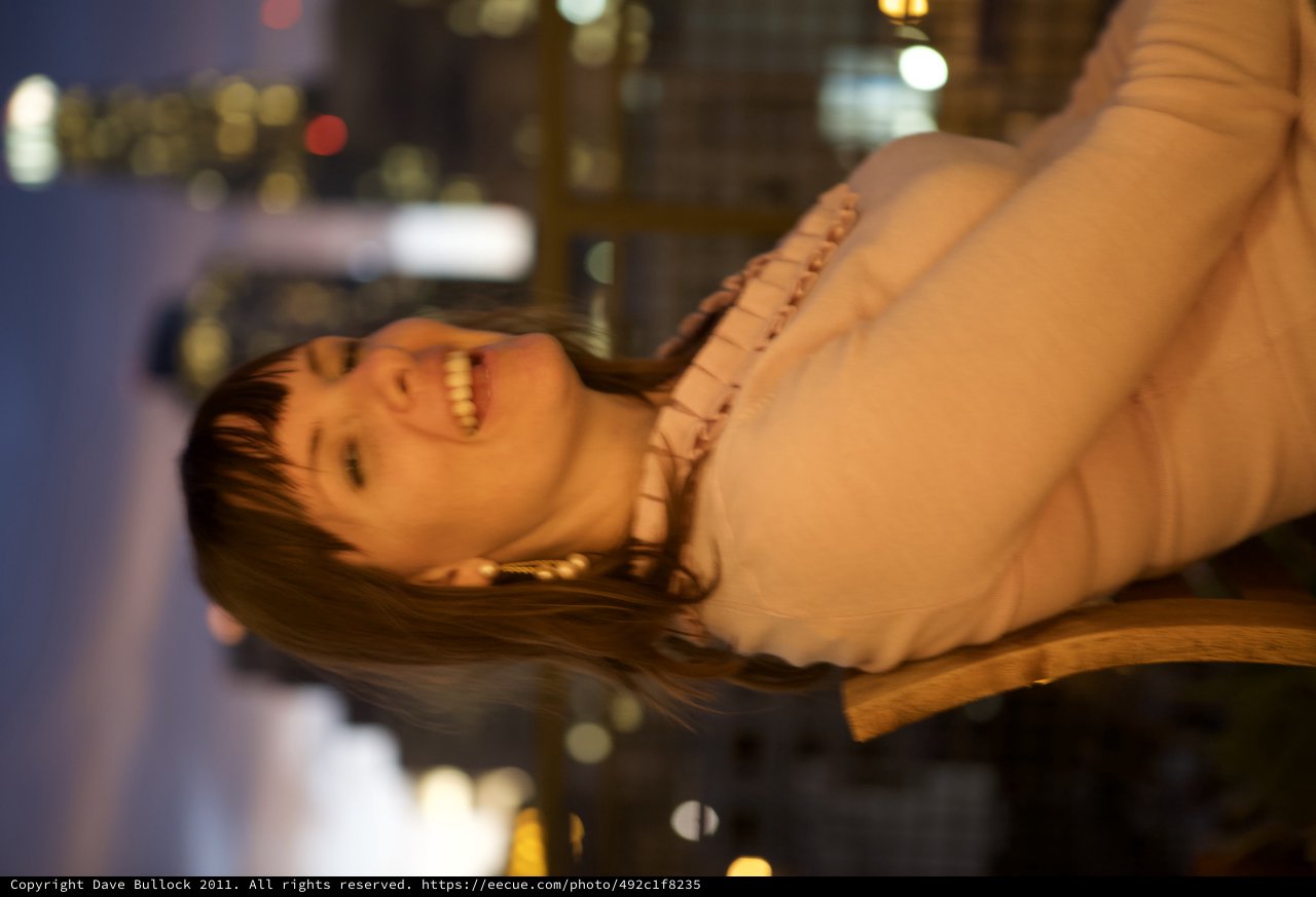 Laughing Woman Against City Skyline at Dusk