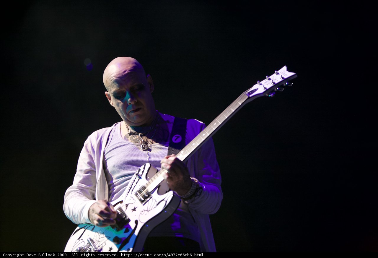Rocking the Stage: Bald Man Shredding on Electric Guitar