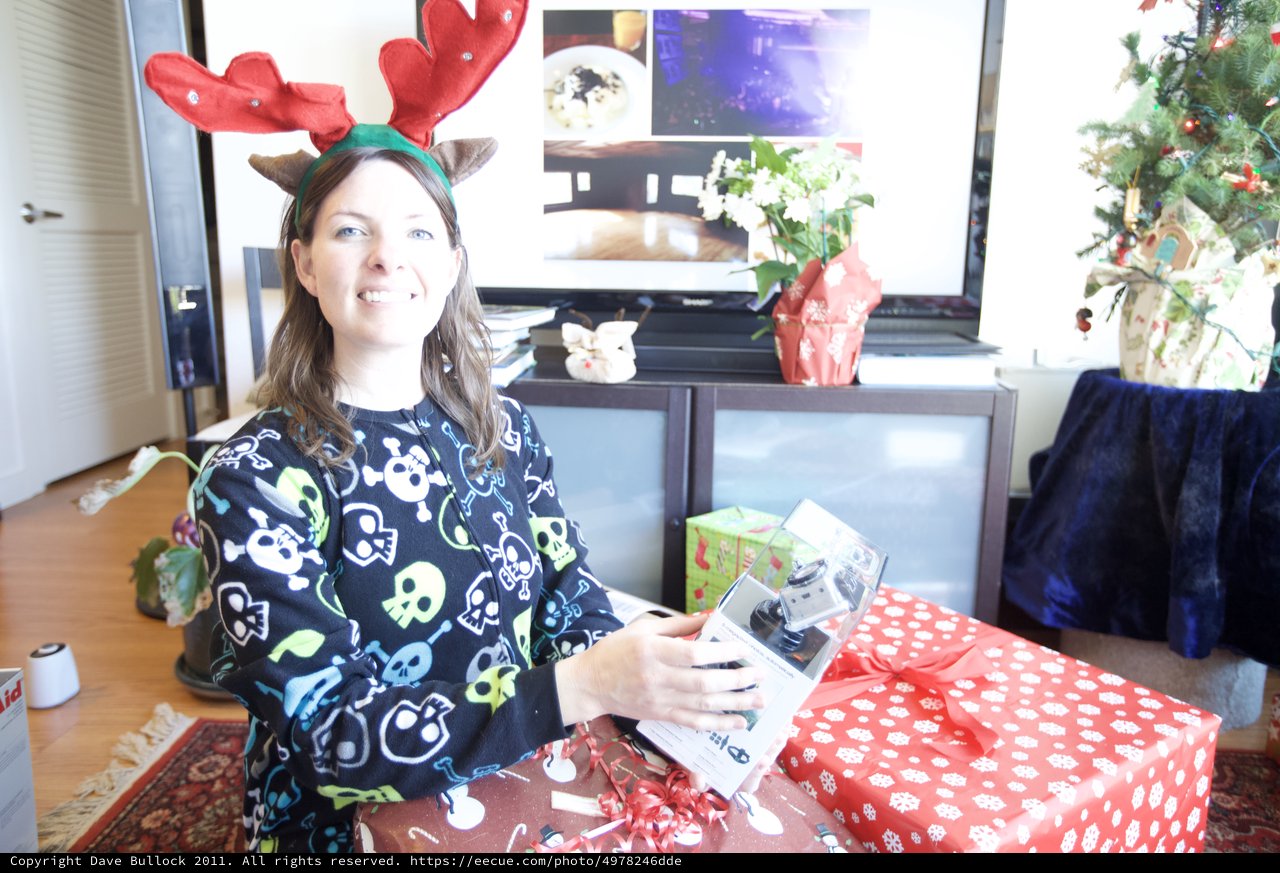 Joyful Christmas Morning Gift Unwrapping with Reindeer Antlers