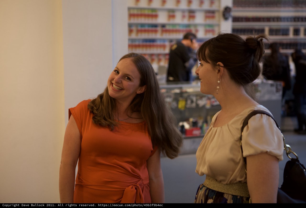 Two Women Sharing a Joyful Conversation at Gallery Event