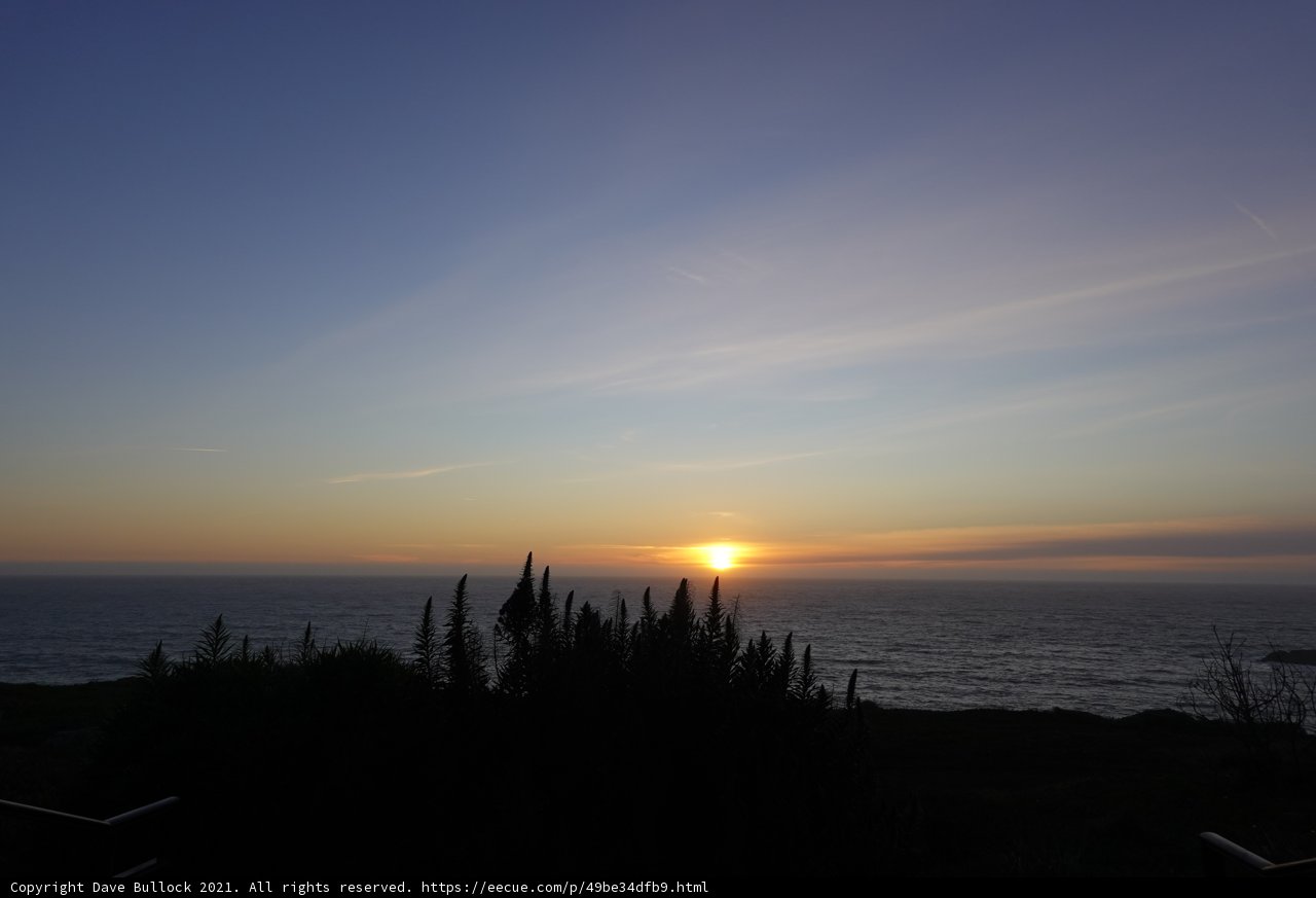 Hillside view of a stunning sunset over the ocean