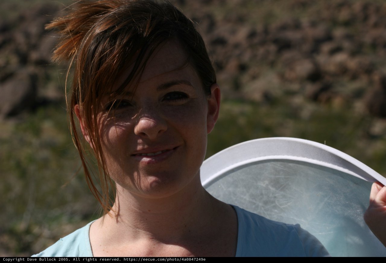 Woman Holding Frisbee Outdoors in Rocky Landscape