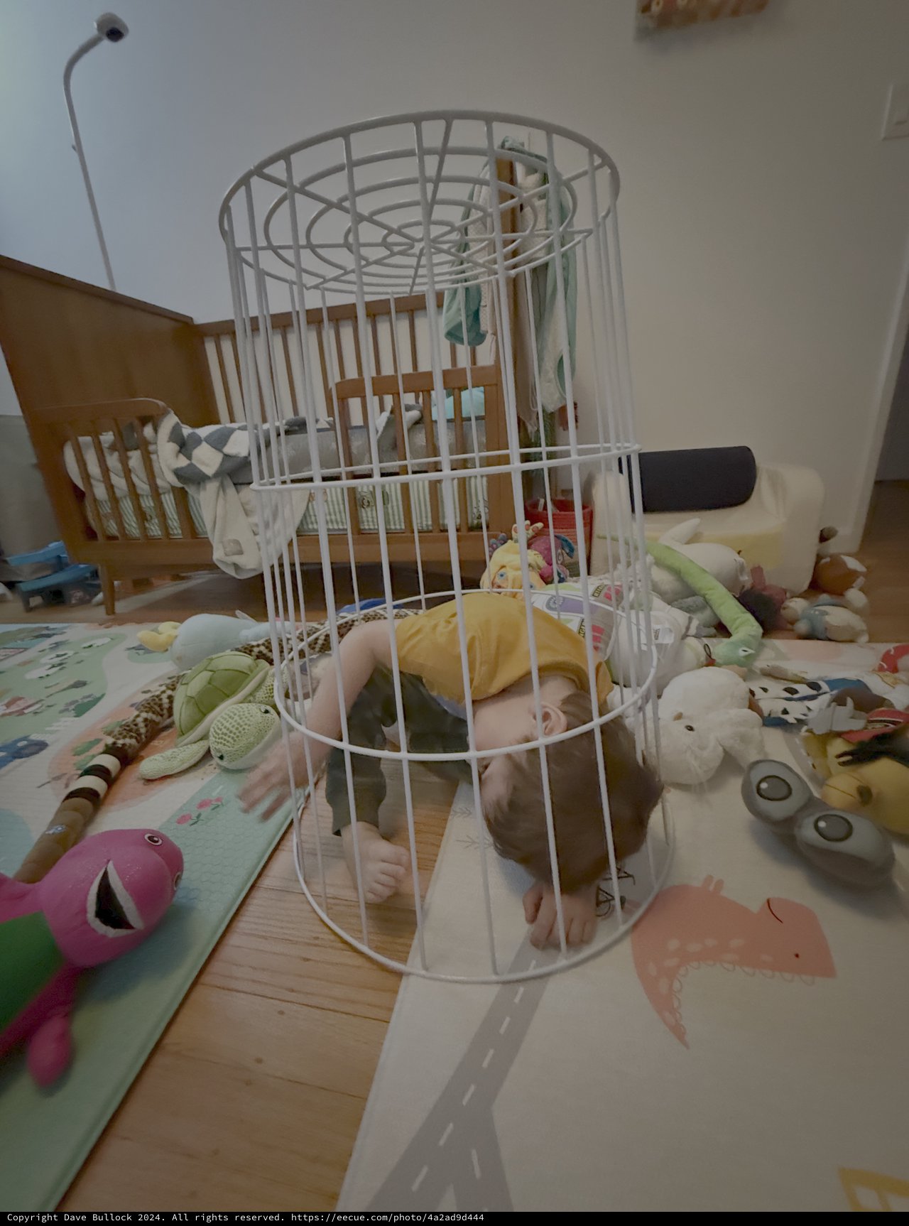 Baby Playing Inside White Wire Laundry Basket