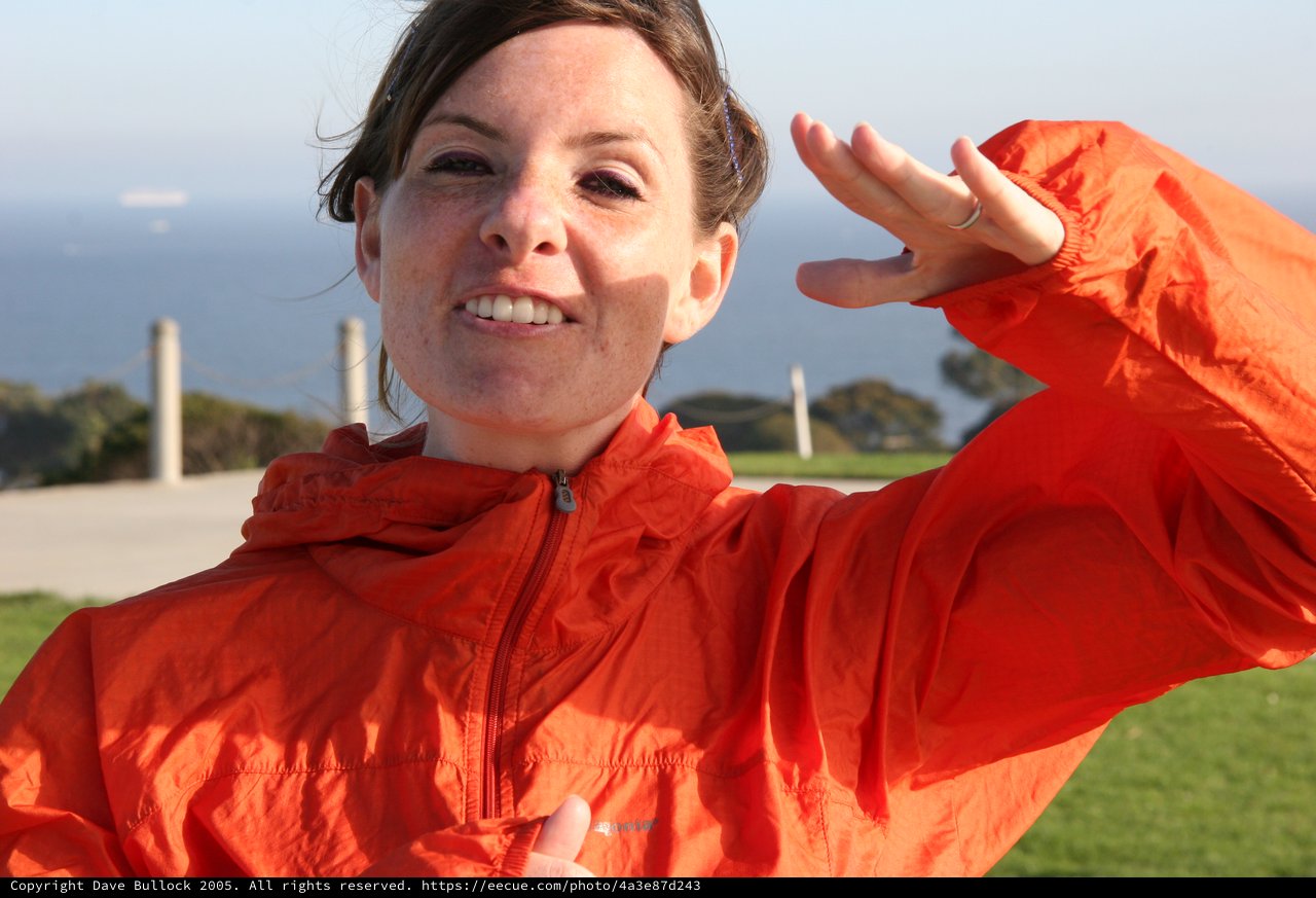Radiant Woman in Orange Jacket by the Sea