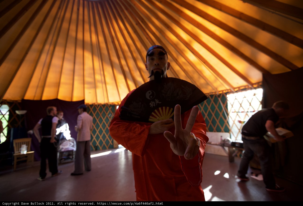 Man in Red Robe Standing in Yurt