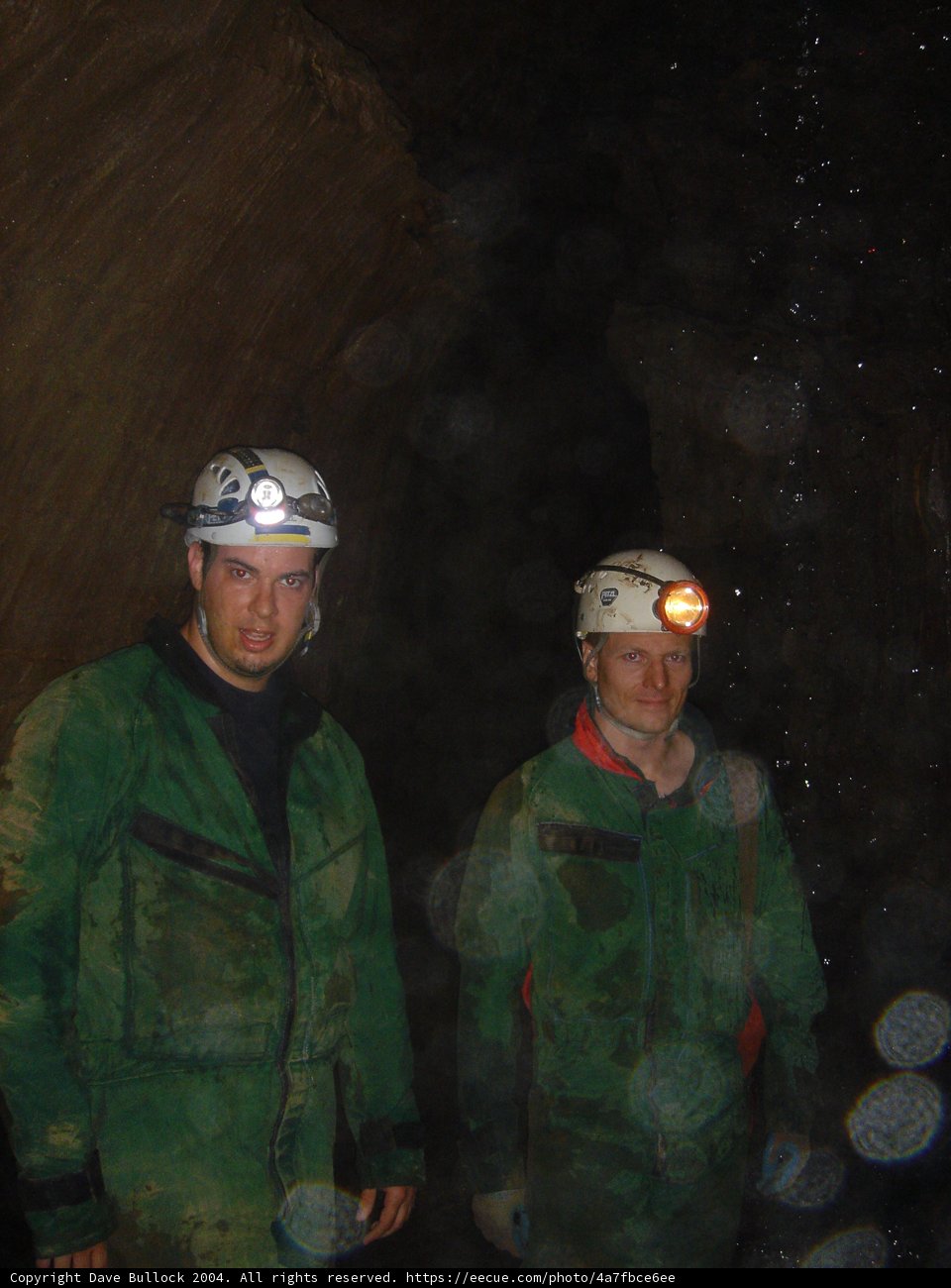 Two Men in Green Jackets Wearing Helmets
