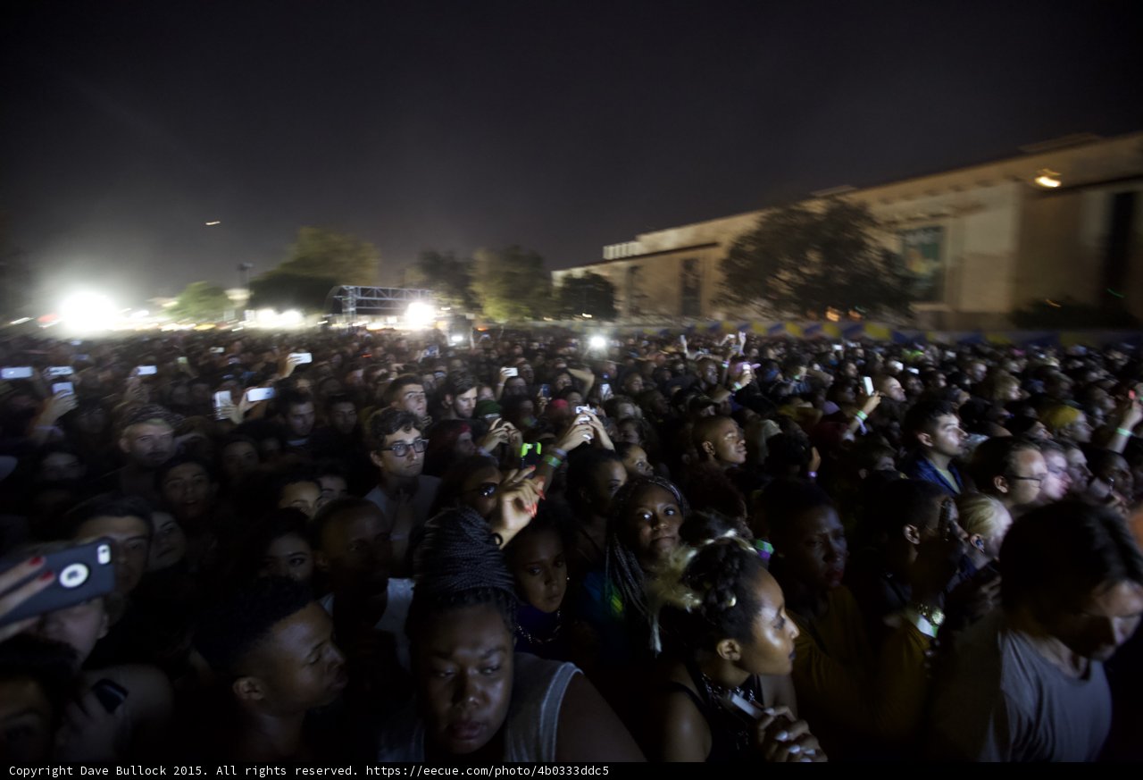 FYF Fest Large Diverse Crowd Night Phones Recording Stage Lights Trees Building Faces Visible