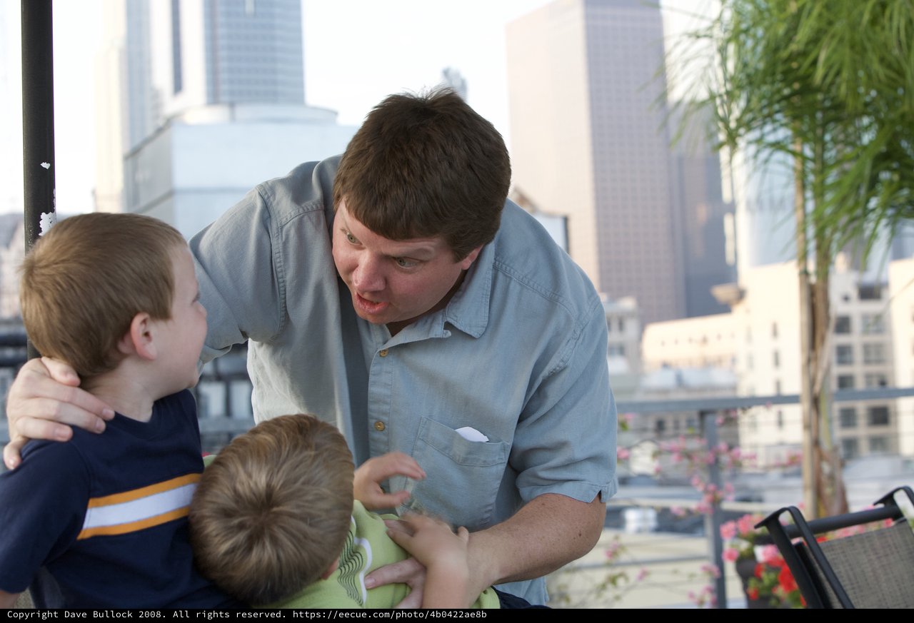 Father Playfully Engaging Two Young Boys on Urban Rooftop