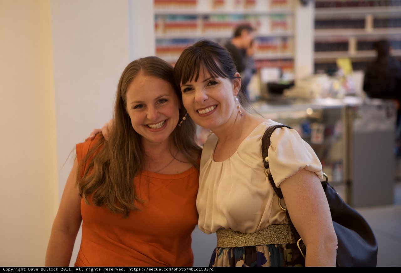 Two Women Smiling Together at Wine Party Event