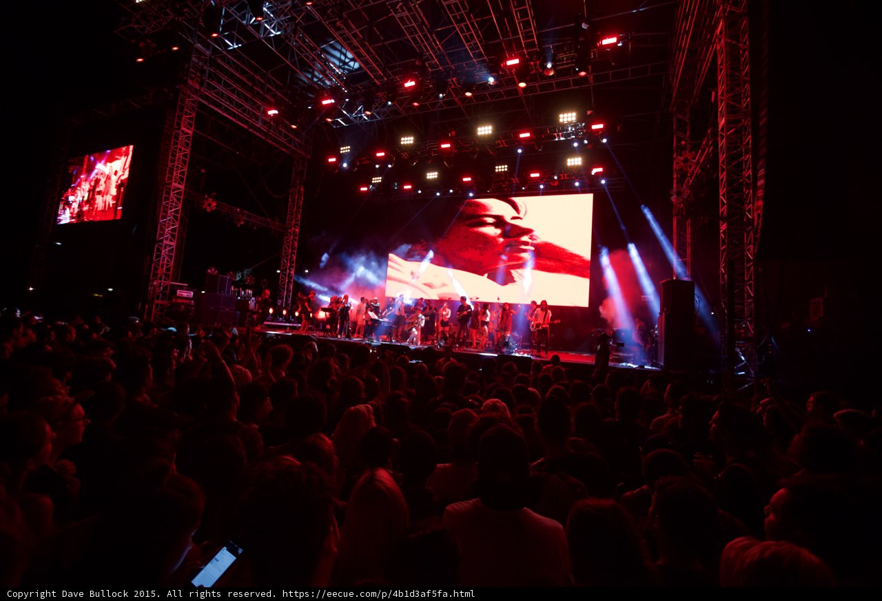 Belle and Sebastian Wide Stage Video Screen Romantic Couple Clear View Red Lighting Ensemble Crowd