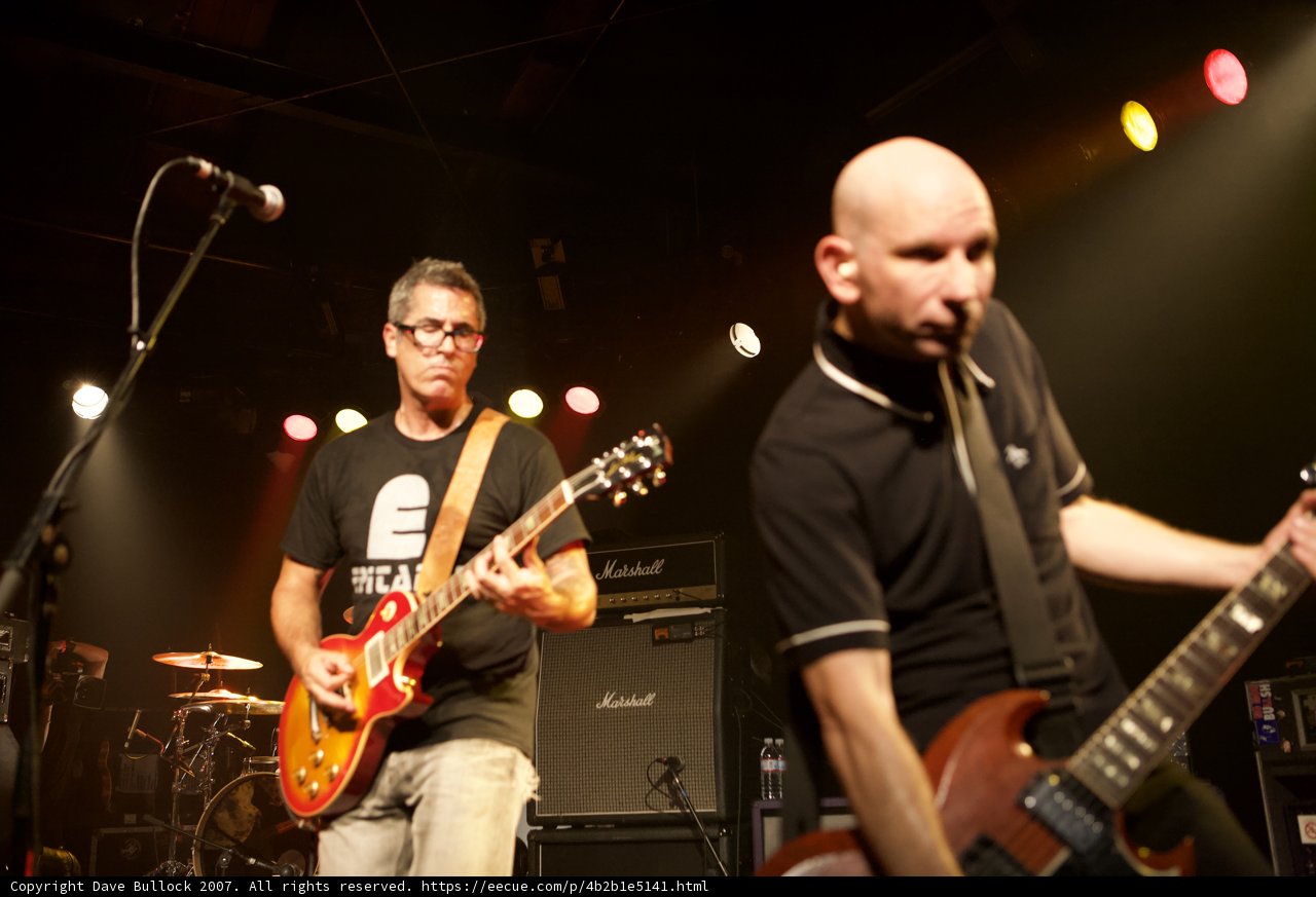 Rocking the Stage: Two Men with Guitars at Bad Religion Concert