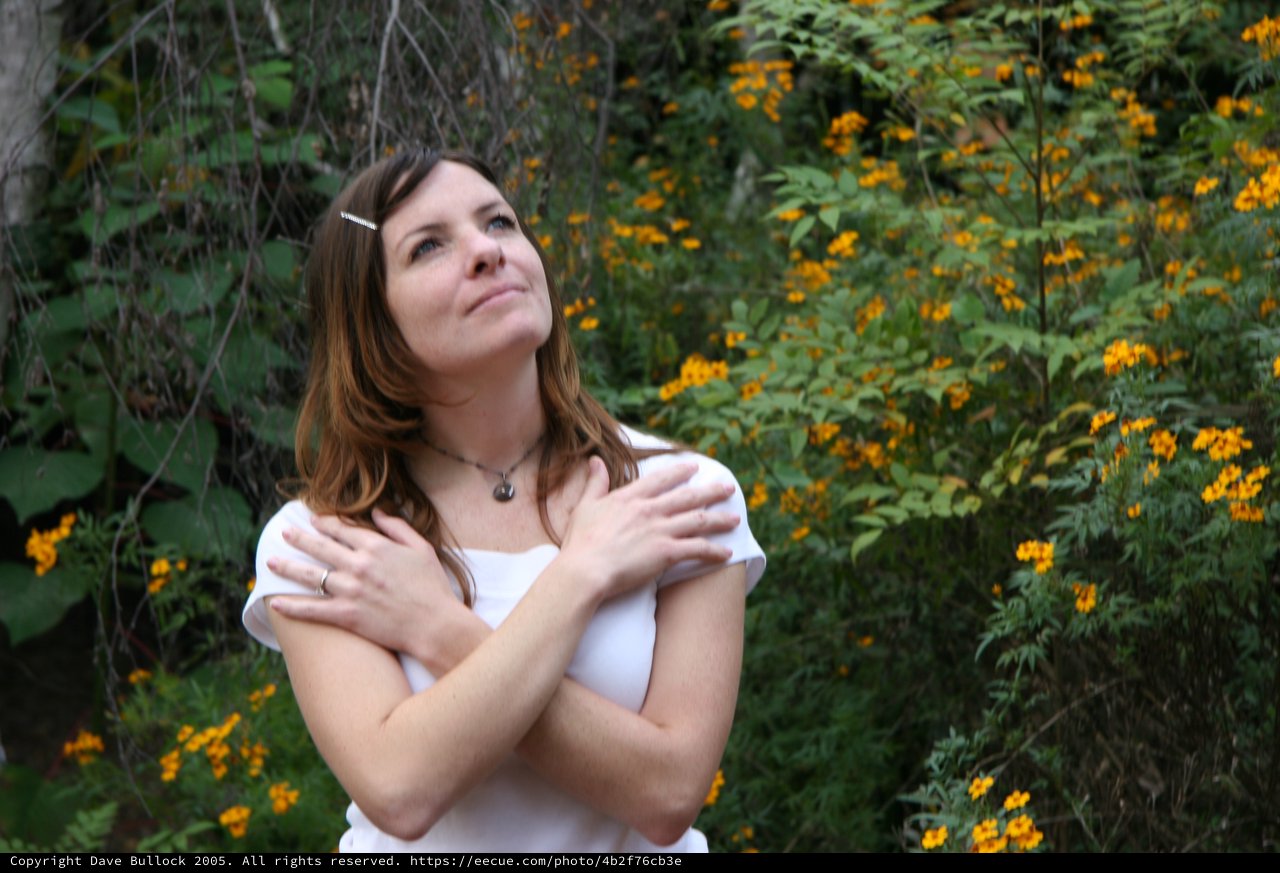 Woman in White Gazing Upward Among Wildflowers
