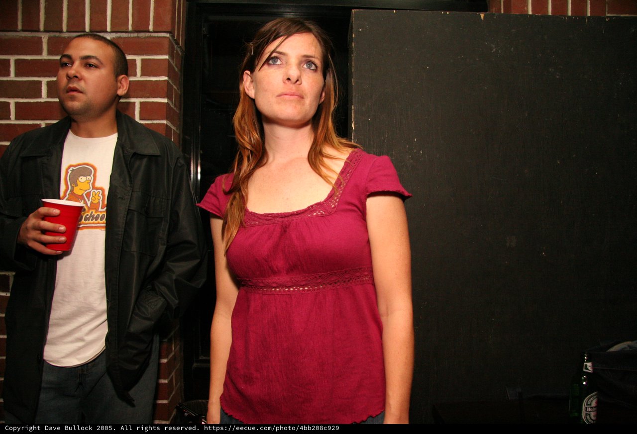 Woman in Red Top Gazes Upward at Nighttime Event