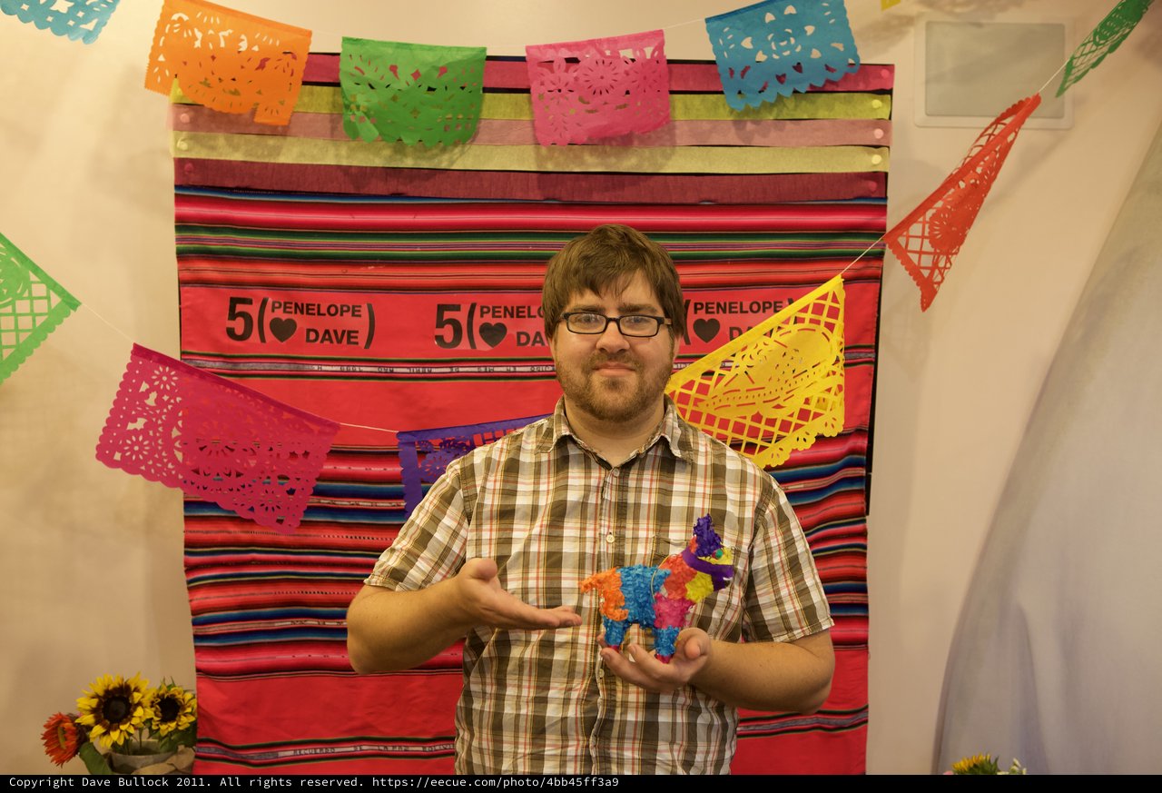 Man Holds Mini Piñata at Mexican Fiesta Anniversary Party