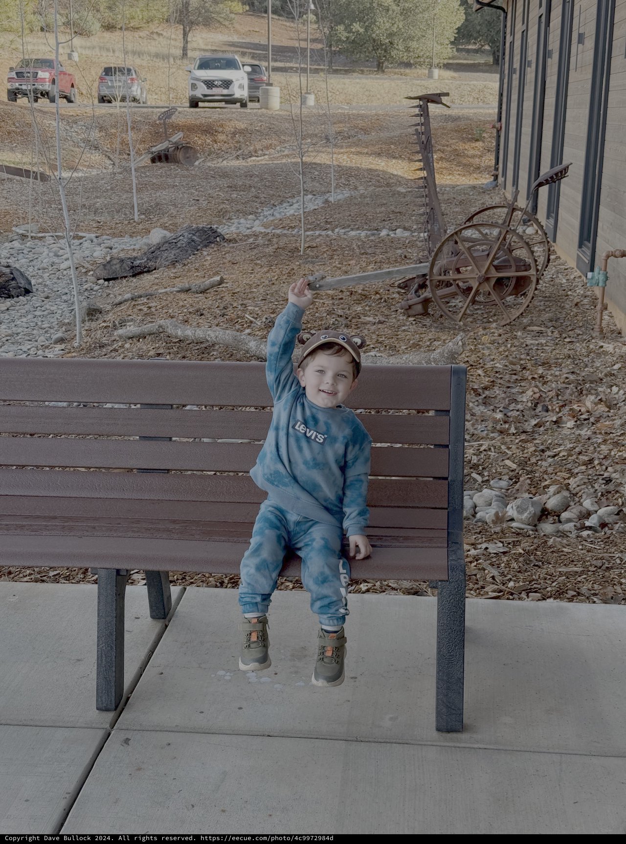 Happy Toddler Waving on Park Bench