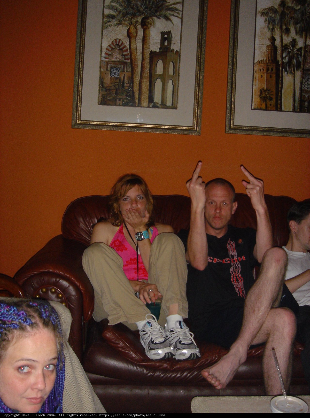 Friends Lounging on Leather Couch at Indoor Gathering