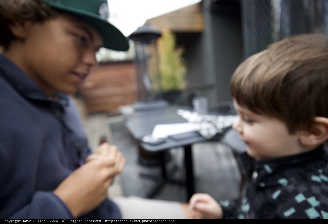 Children Sharing a Warm Moment at Outdoor Café