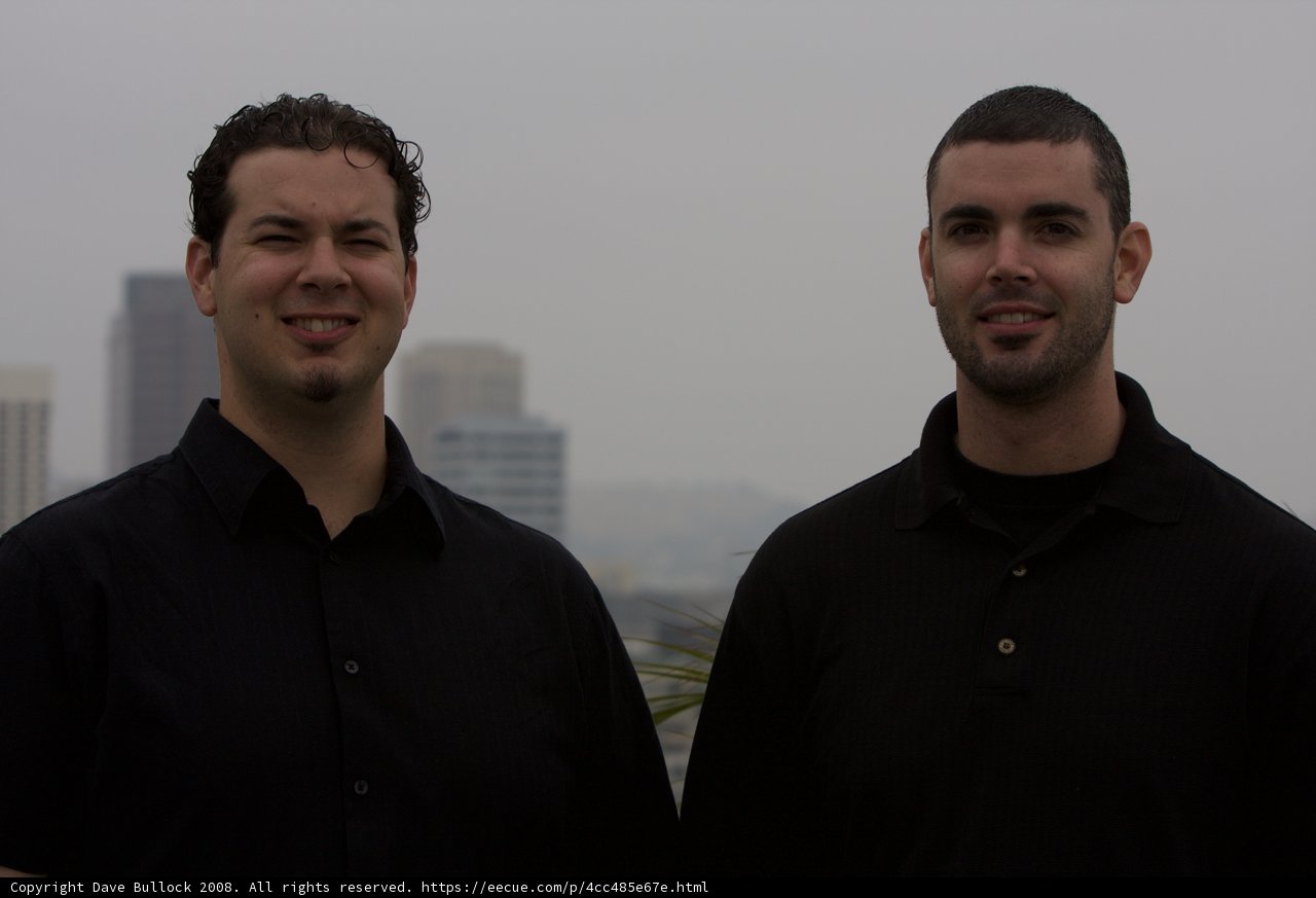 Two Happy Men in Black Shirts Posed Outdoors