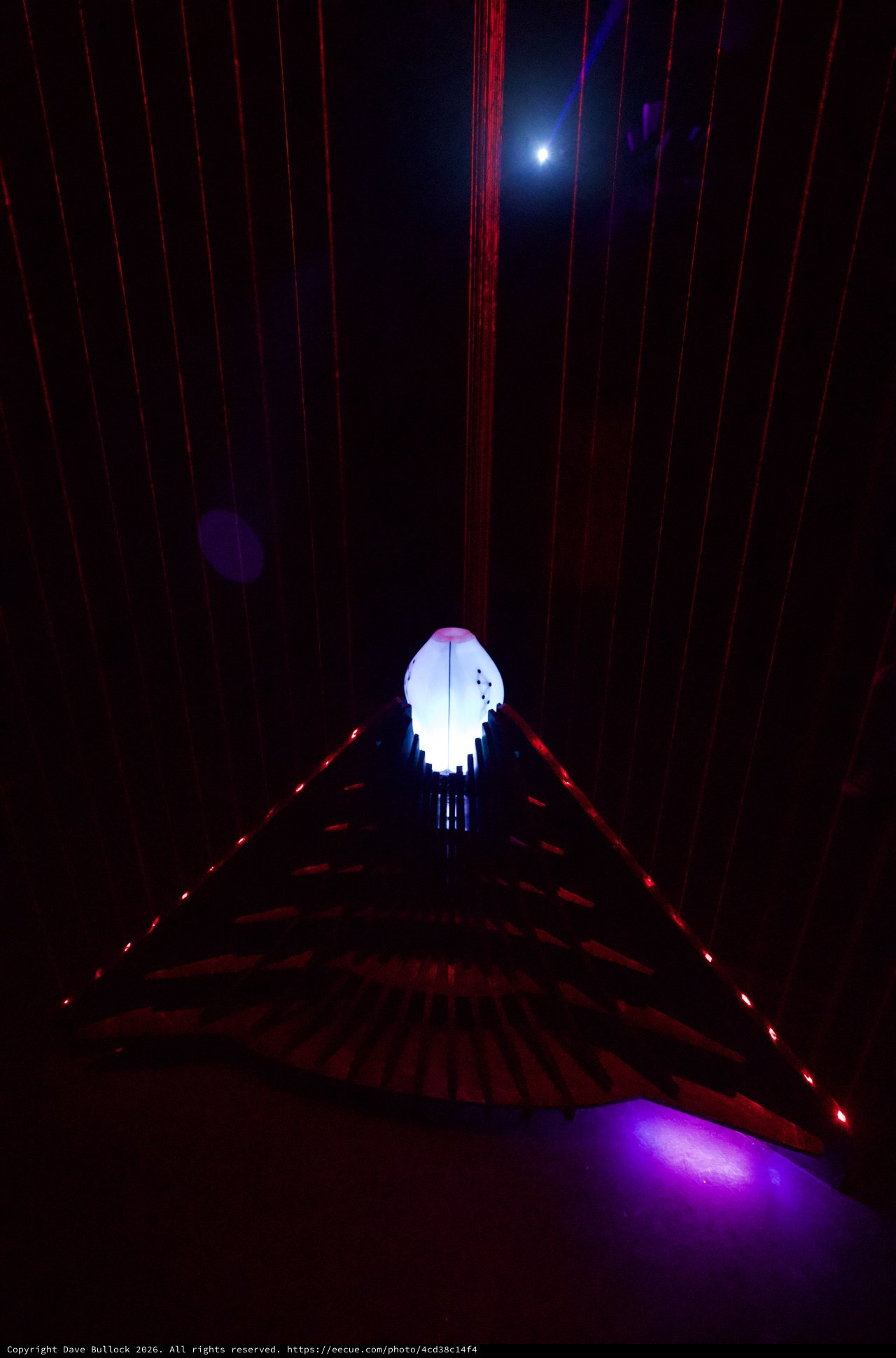 Illuminated Skull Installation in Dark Corridor with Red Laser Grid
