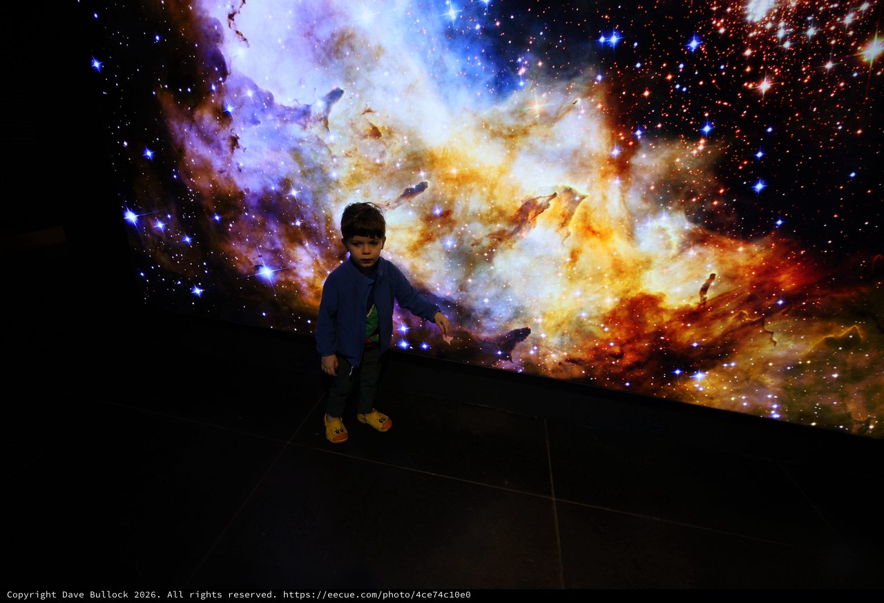 Child Explores Cosmic Nebula at Space Center