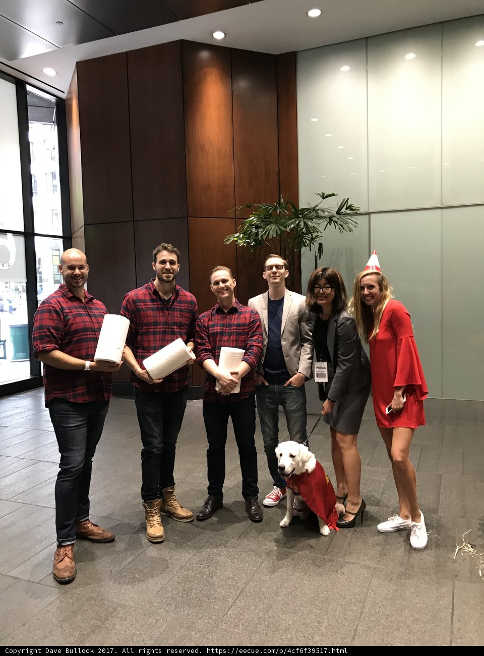 Group of red shirted adults holding papers