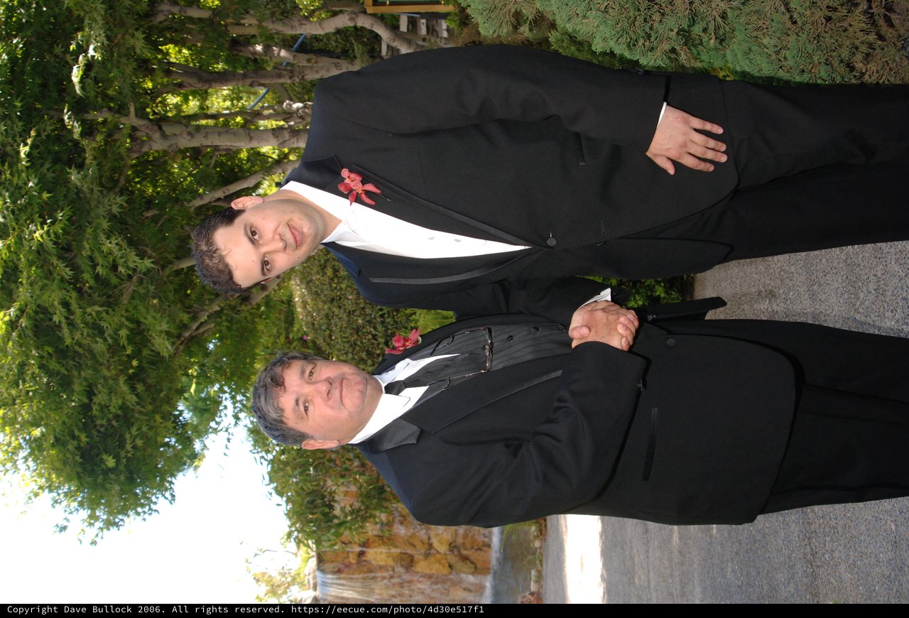 Two Men in Tuxedos Shaking Hands at Wedding