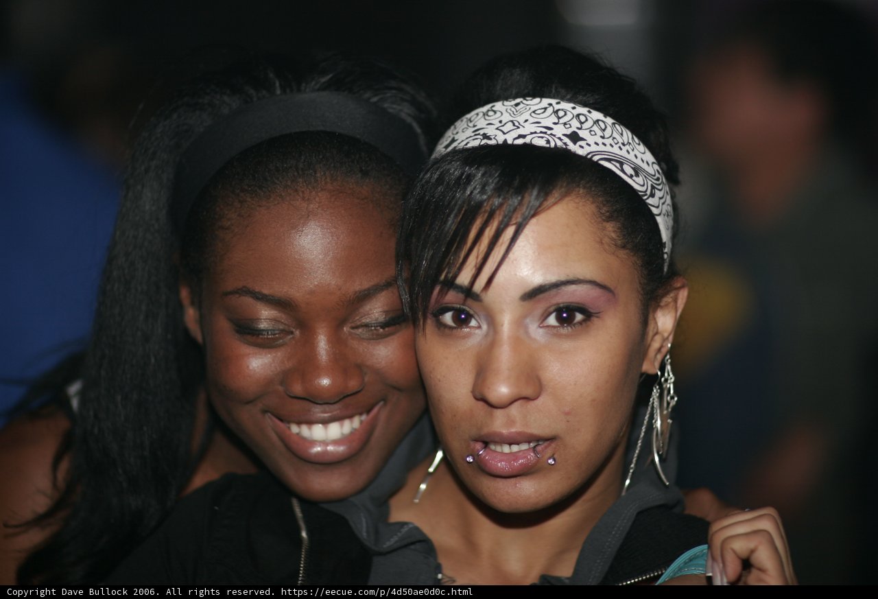 Two Women Flaunting Their Headgear with Smiling Faces