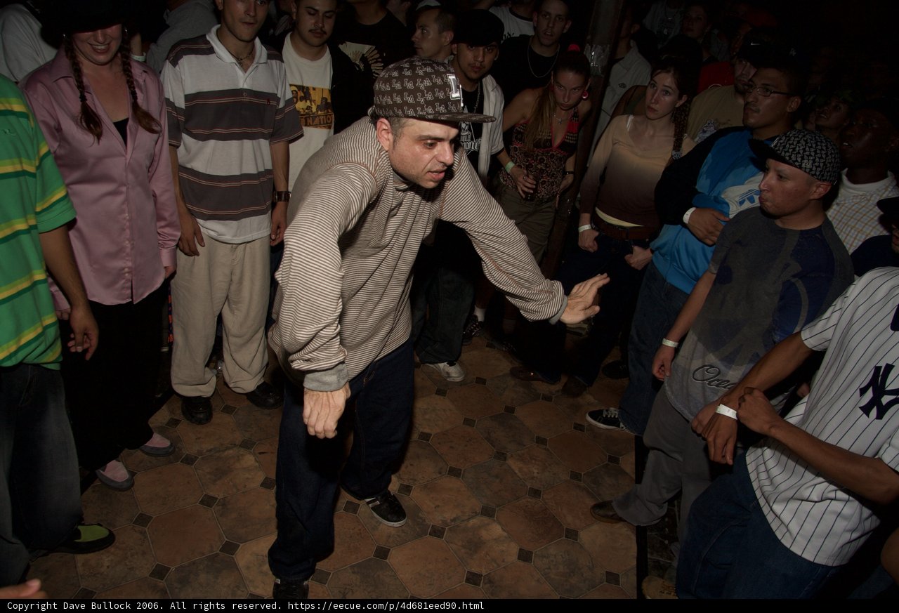 Man in Grey Shirt and Caps Among Urban Crowd