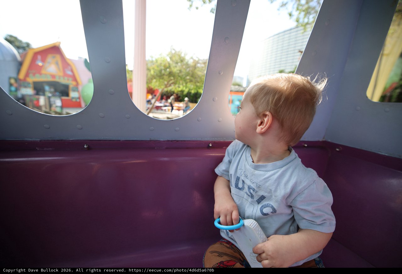 Young Child Gazing Through Playground Windows at Theme Park