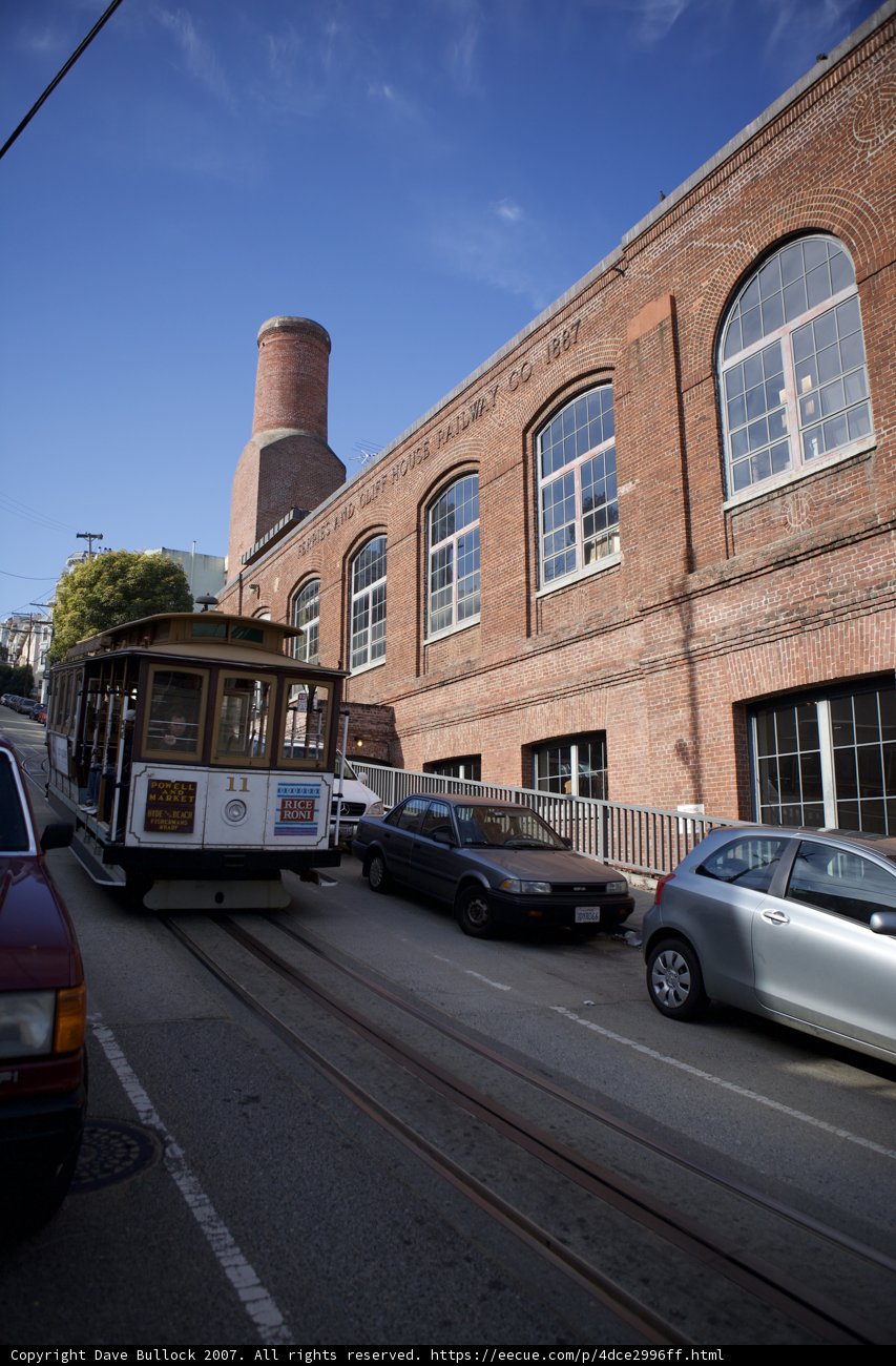 Cable Car Parked in Front of Brick Building