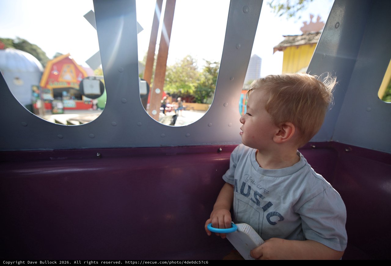 Toddler Gazing Through Playground Portal Window
