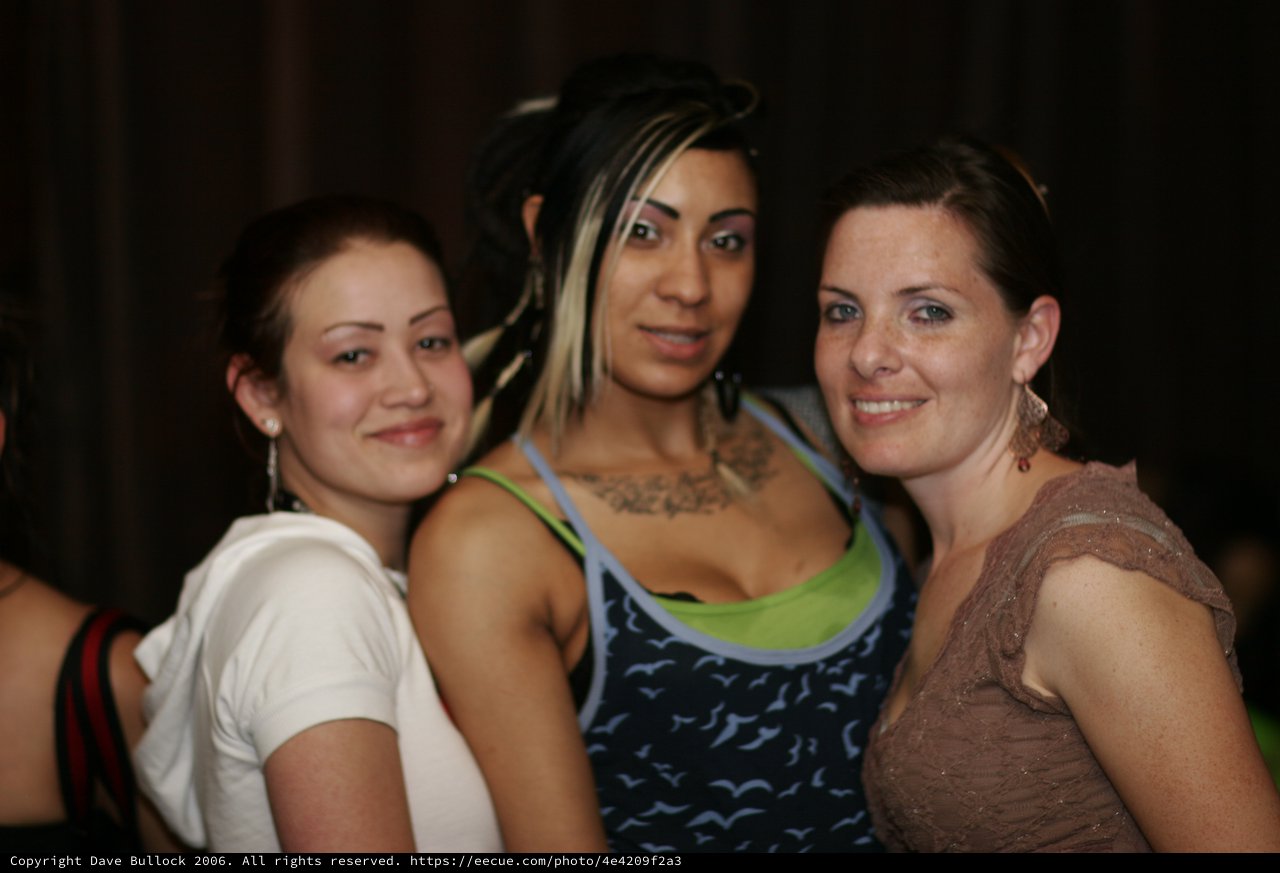 Three Friends Posing at a Nightclub Anniversary Party