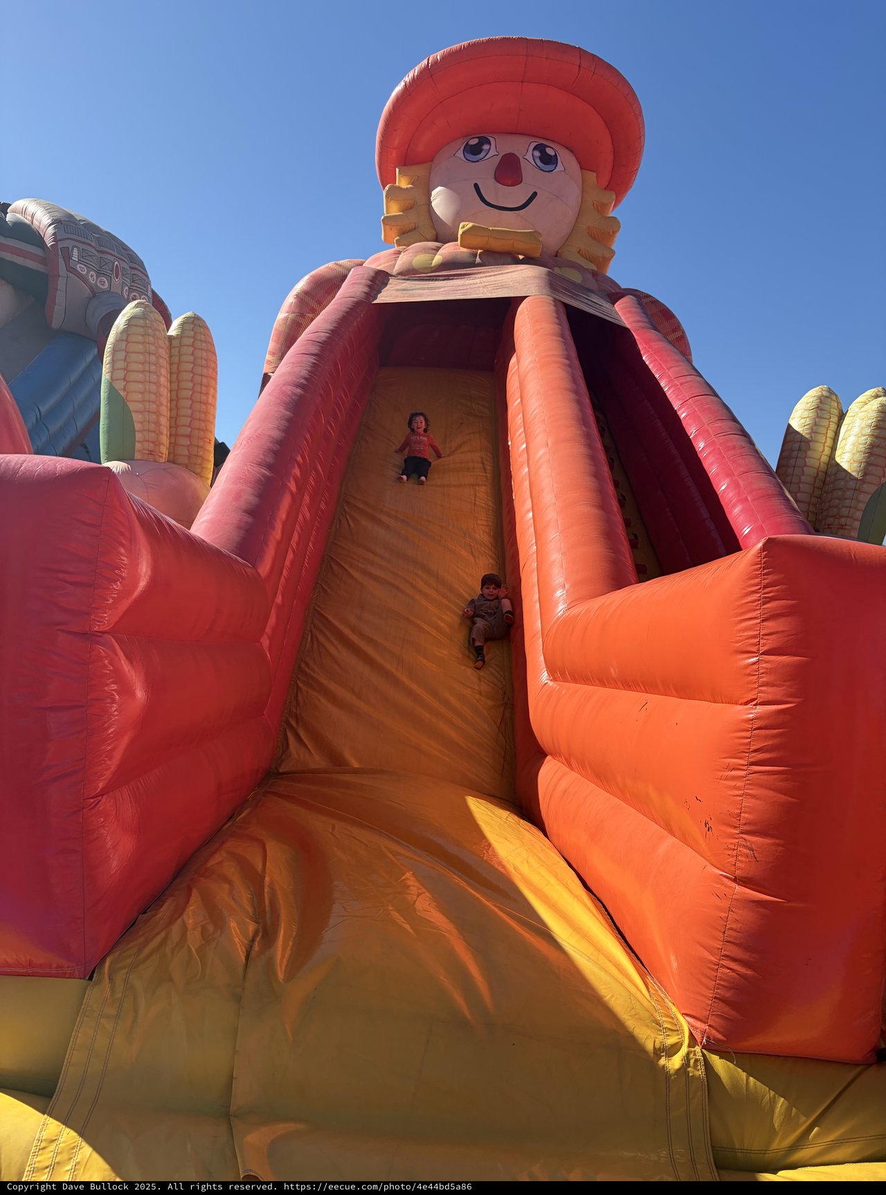 Children Sliding Down Giant Inflatable Harvest Doll