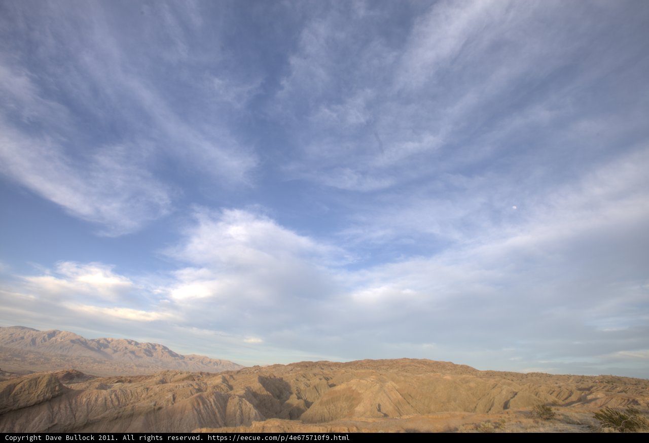 Hilltop View of Majestic Mountains and Clouds