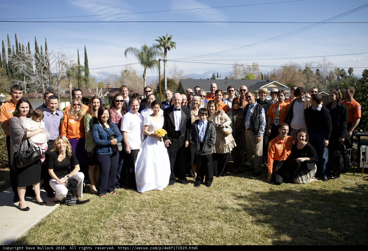 Wedding Party Poses for Photo in Front of Beautiful Home