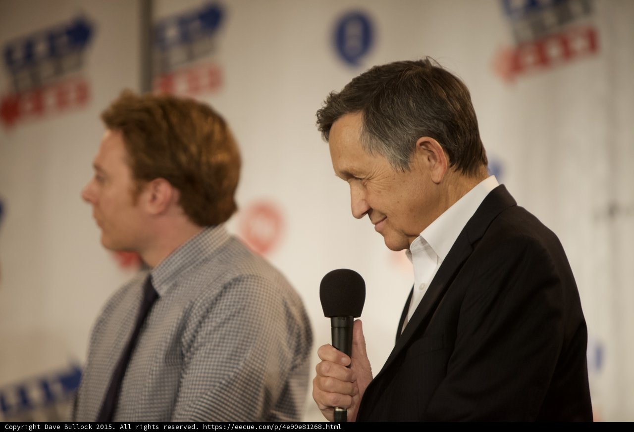 Press Conference with Two Men Speaking into Microphones