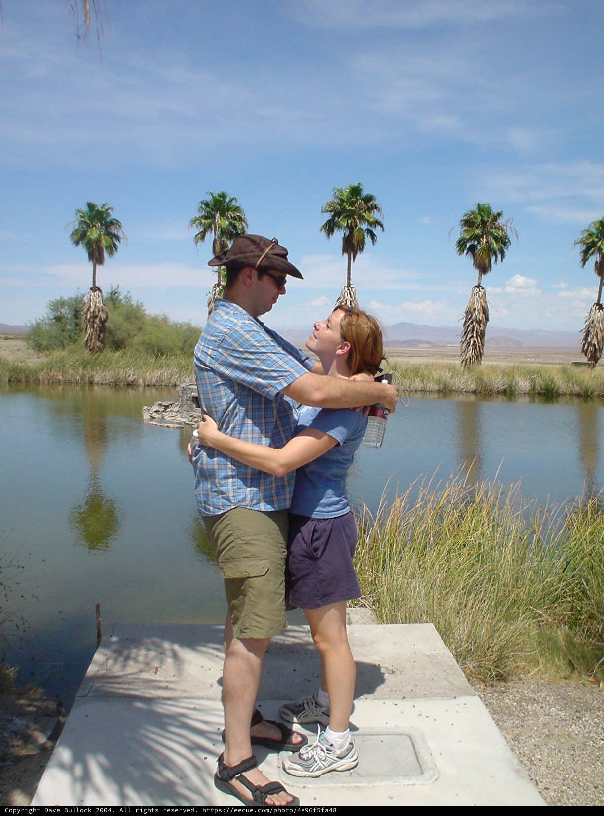 Couple Embracing at Desert Oasis Pond