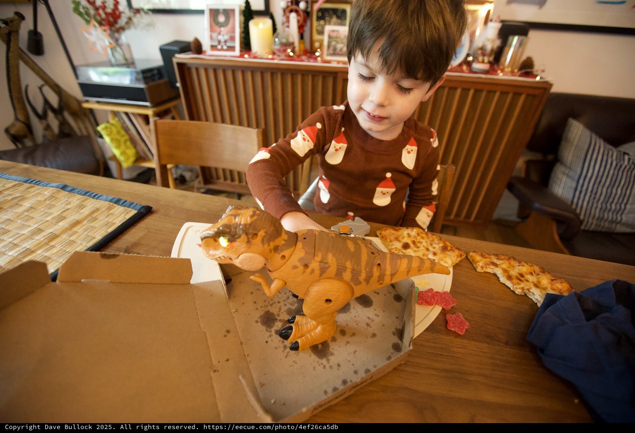 Child Delighting in Dinosaur-Shaped Christmas Pizza
