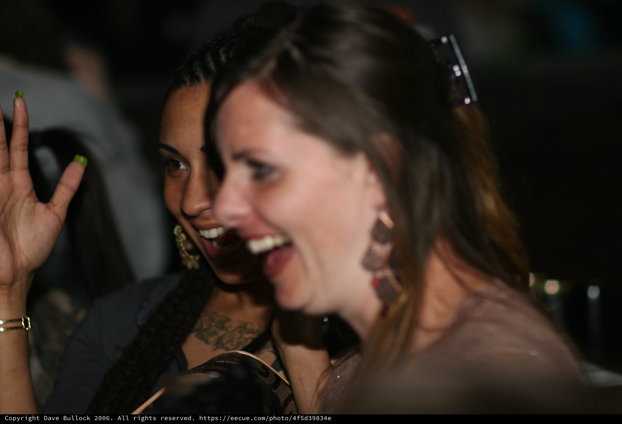 Two Women Laughing Together at Nighttime Event