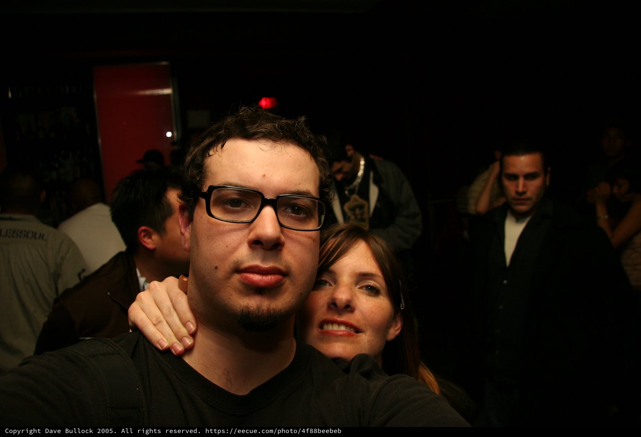 Two Friends Pose at a Dimly Lit Nightclub