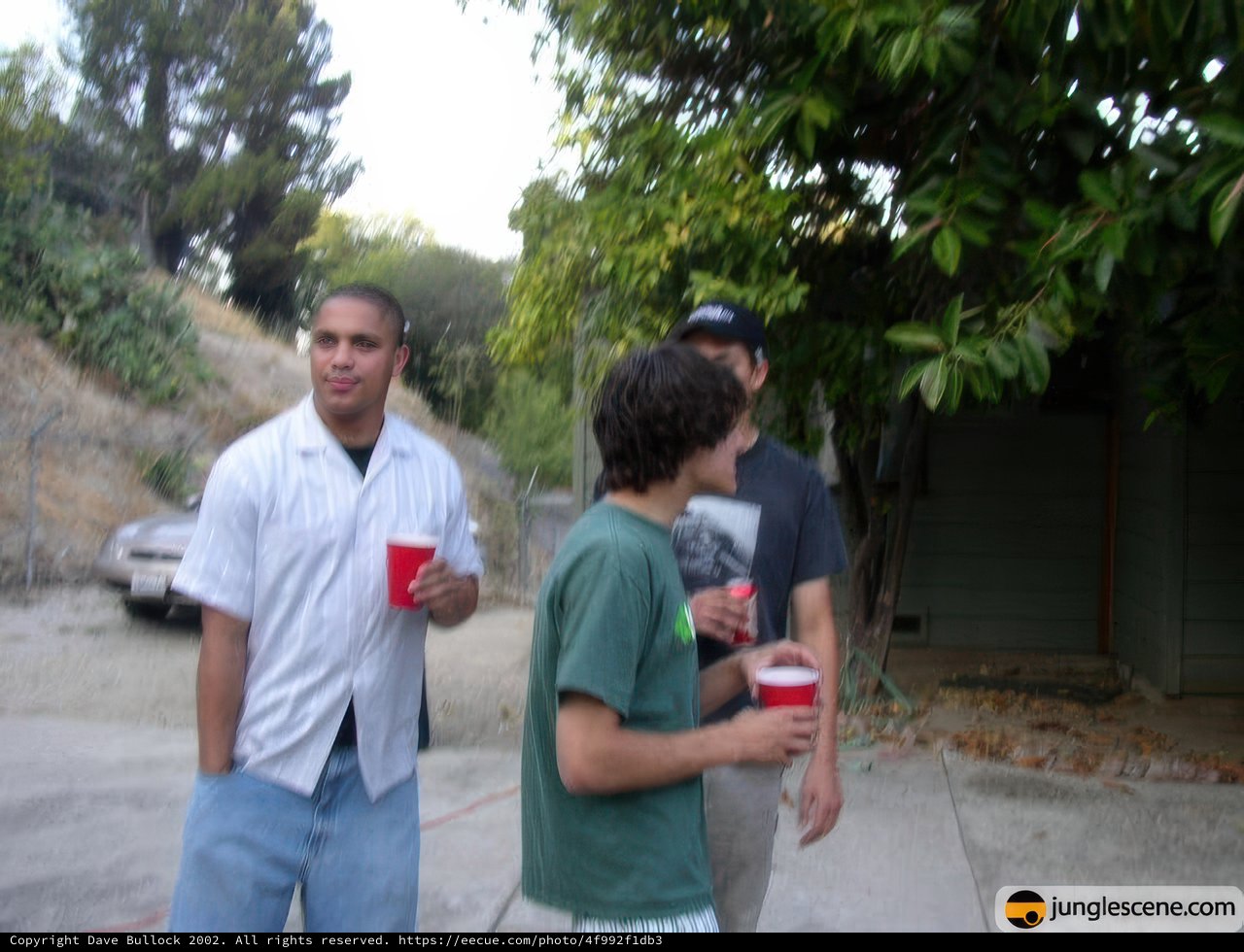 Three young men enjoying drinks outside