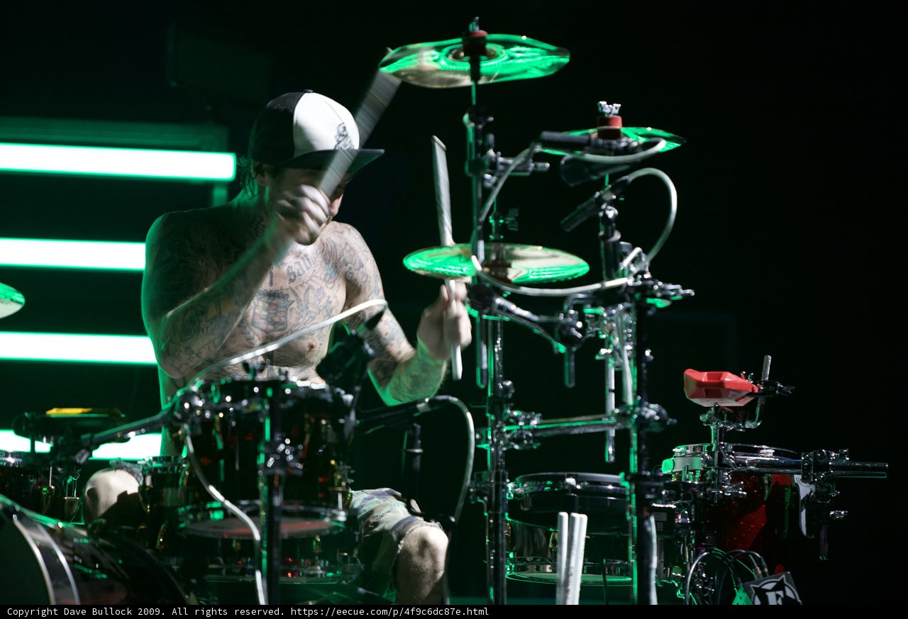 Drumming Tattooed Performer Shining on Stage