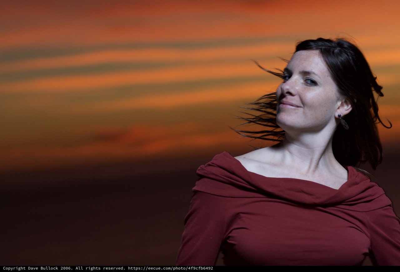 Woman in Red Against a Fiery Sunset Sky