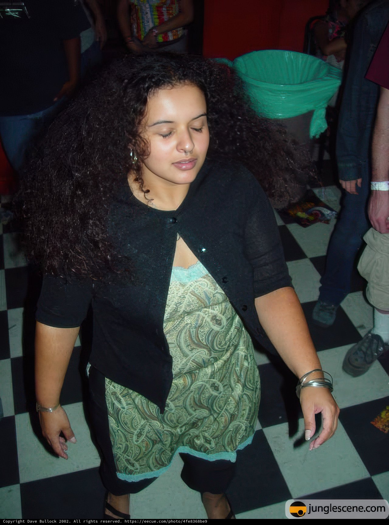 Curly-haired woman in denim and jewelry