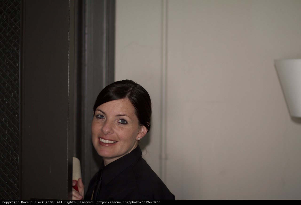Woman Smiling Playfully Around a Doorframe