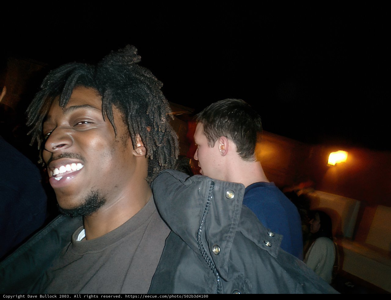 Happy Man in Jacket Among Night Sky Crowd