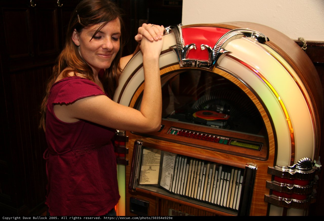 Young Woman Leaning on Classic Vintage Jukebox